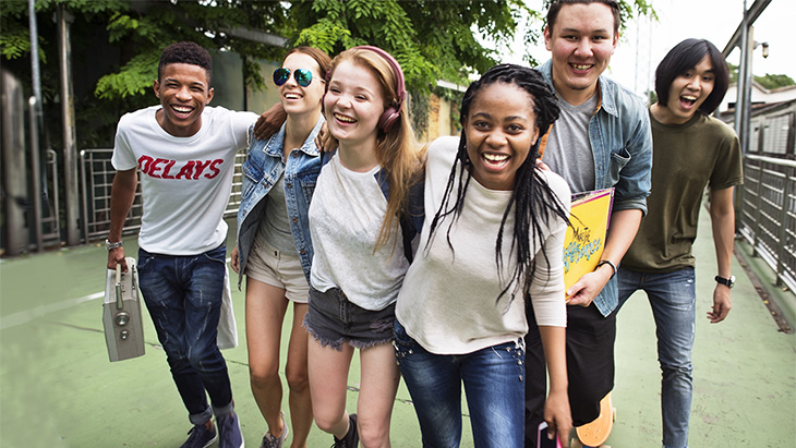 group of teens having fun walking down the street