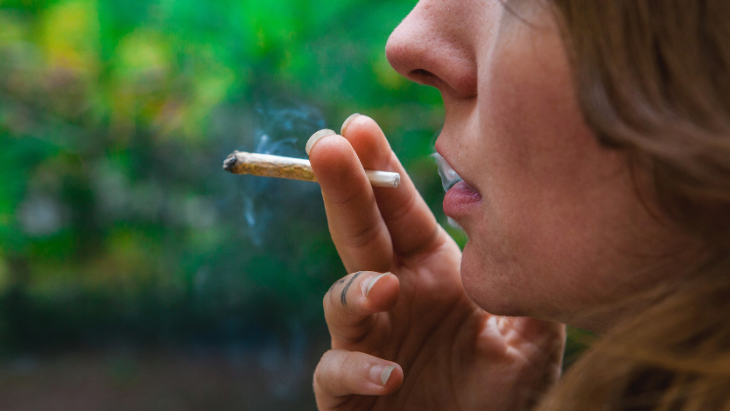 a woman smokes a legal cannabis joint