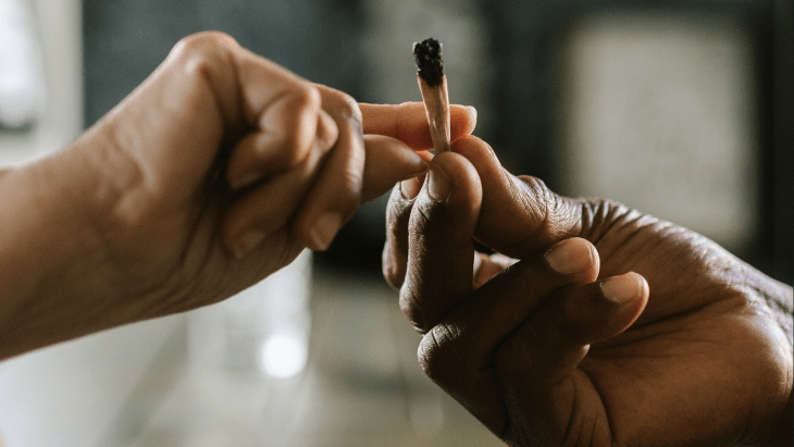 close up of hands passing a legal cannabis joint