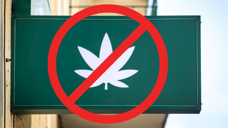 a cannabis dispensary sign with a red circle with a line through it representing "no"