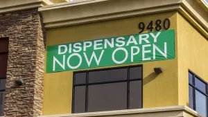 Banner reading "Dispensary now open" hangs on the exterior of a legal marijuana dispensary